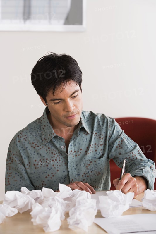 Businessman with crumpled paper balls. Photo: Rob Lewine