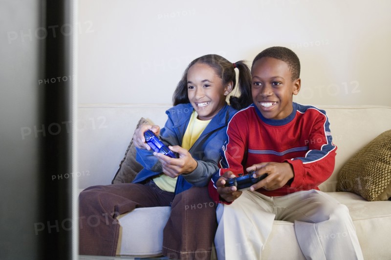 Brother and sister (10-13) playing video game. Photo: Rob Lewine