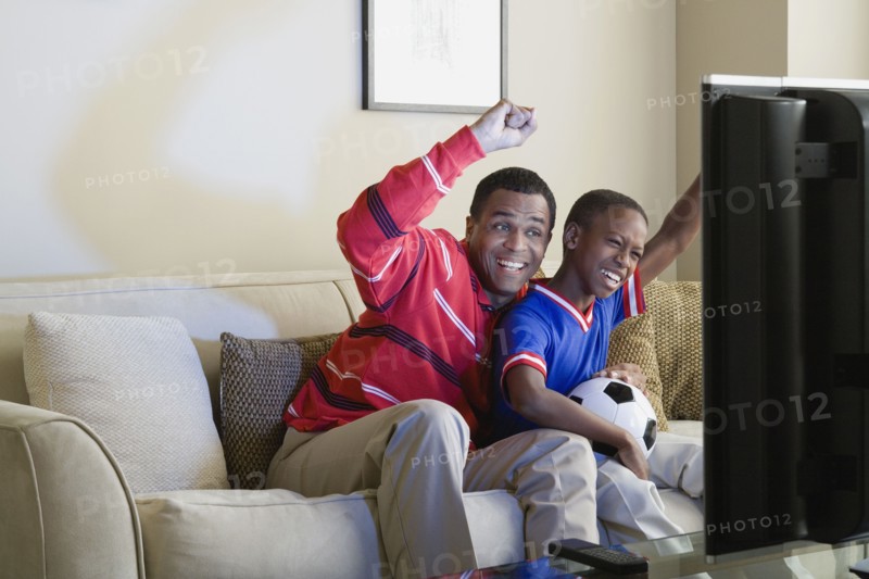 Father and Son (12-13) watching sports on tv. Photo : Rob Lewine