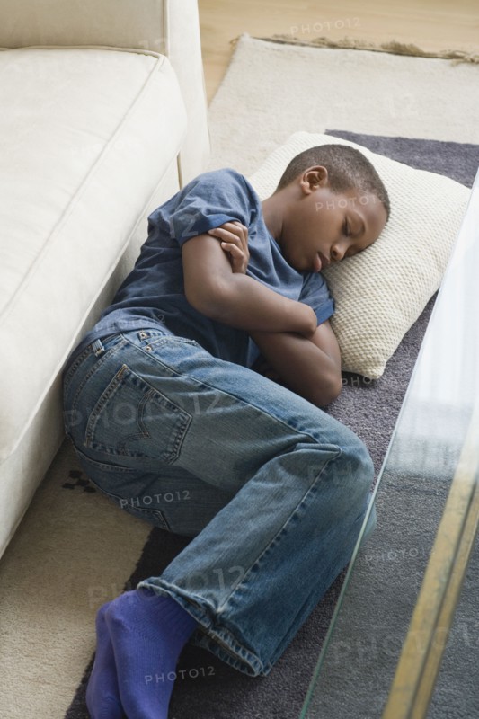 Boy (12-13) sleeping on carpet. Photo: Rob Lewine