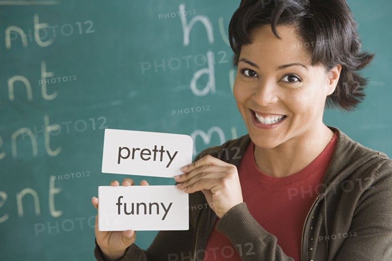 Portrait of female teacher holding text tags. Photo: Rob Lewine