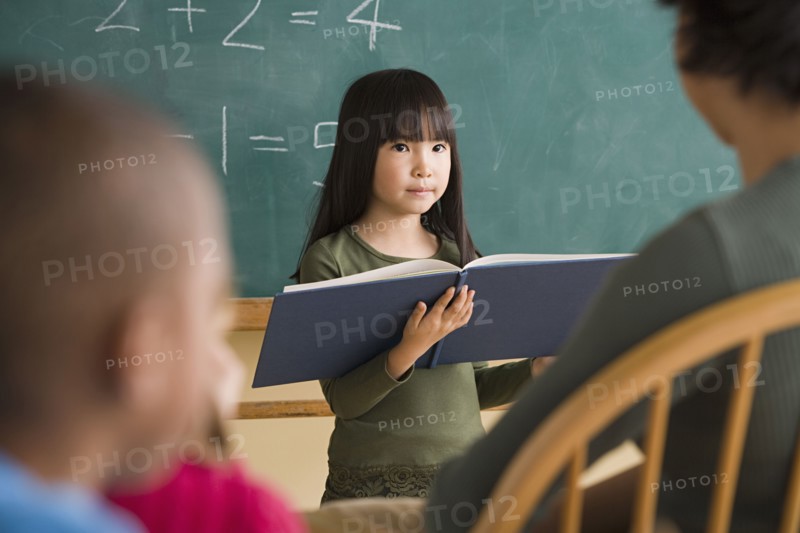 Girl (6-7) having presentation in classroom. Photo : Rob Lewine