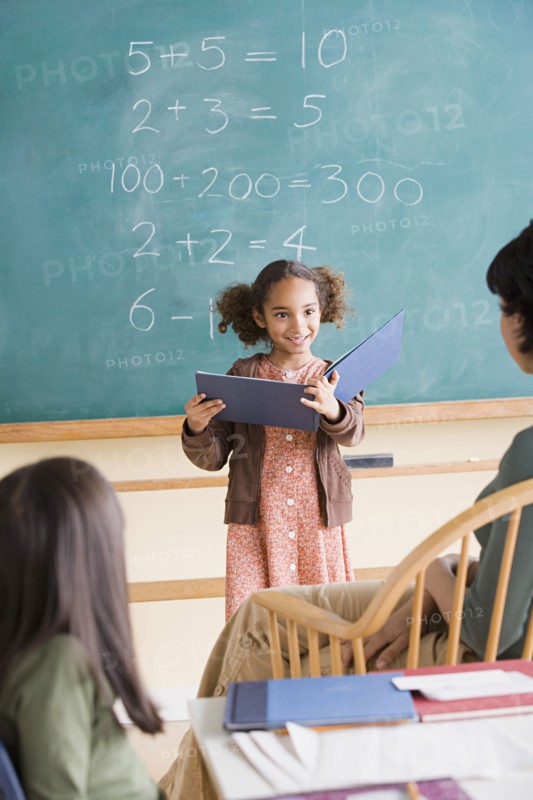 Girl (6-7) having presentation in classroom. Photo : Rob Lewine