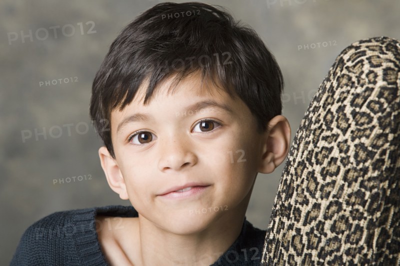 Portrait of smiling boy (8-9) looking at camera, studio shot. Photo : Rob Lewine