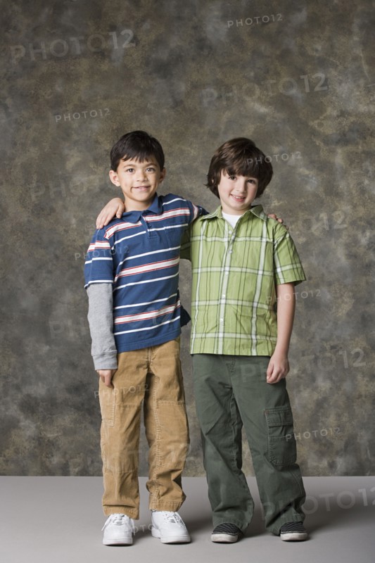 Two boys (6-7, 8-9) standing together, studio shot. Photo : Rob Lewine