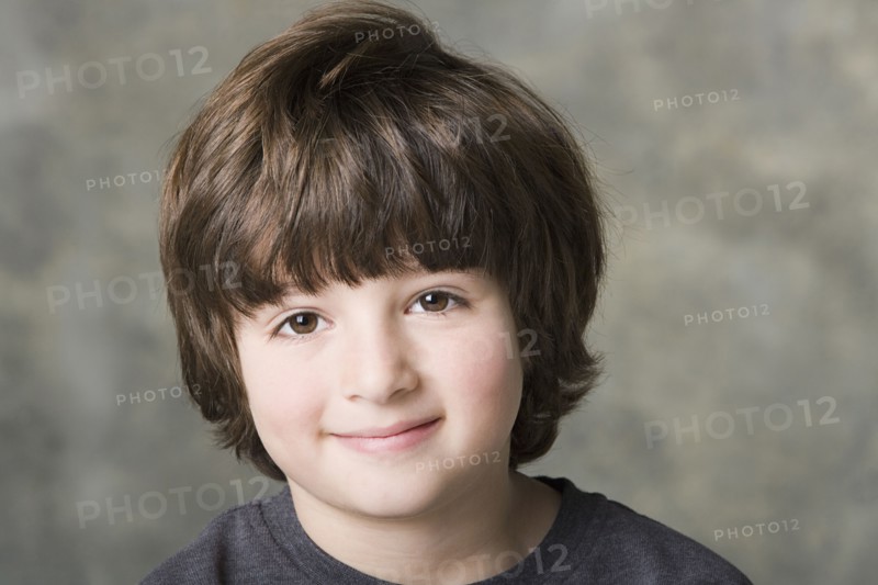 Portrait of smiling (6-7) boy, studio shot. Photo : Rob Lewine