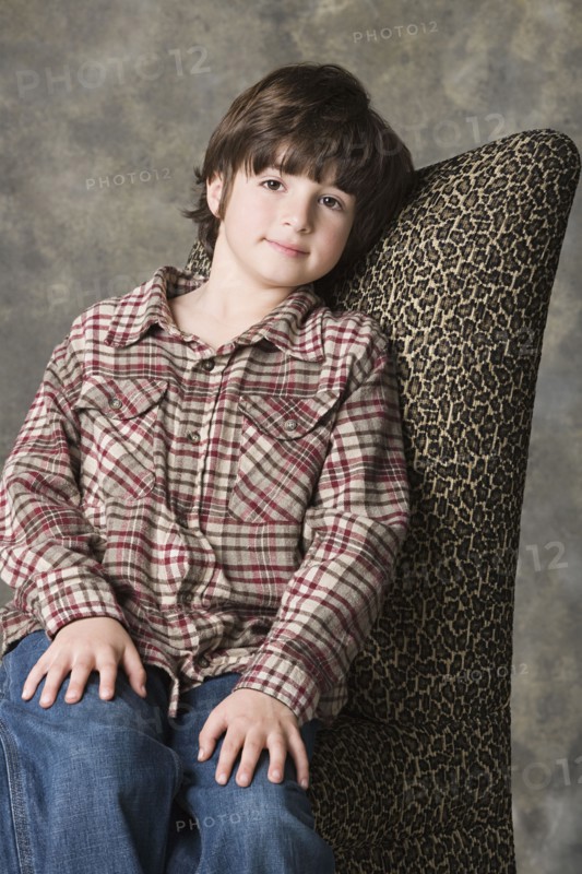 Portrait of smiling (6-7) boy, studio shot. Photo: Rob Lewine