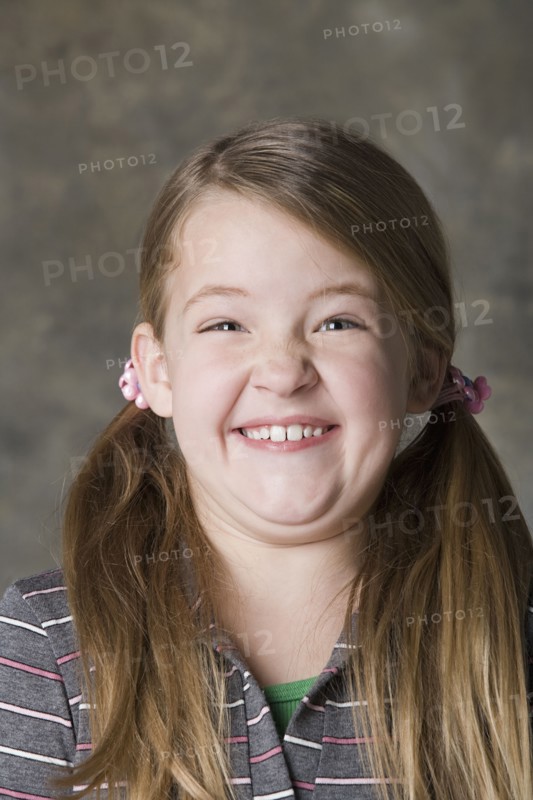 Portrait of smiling girl (8-9), studio shot. Photo: Rob Lewine