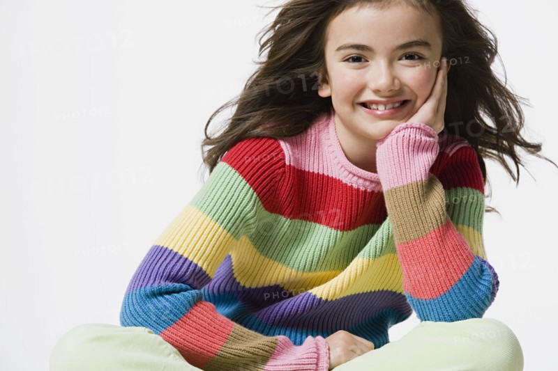 Portrait of smiling girl (8-9), studio shot. Photo : Rob Lewine