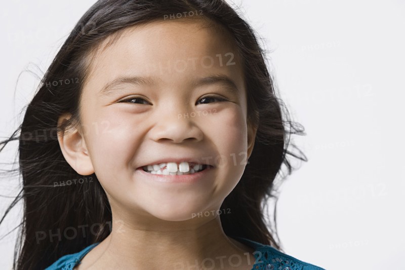 Portrait of smiling girl (8-9), studio shot. Photo : Rob Lewine