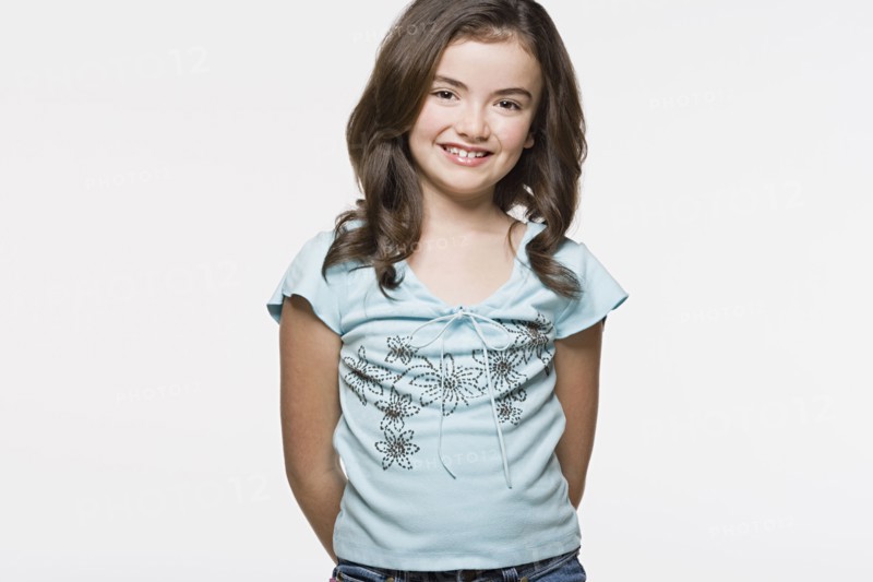 Portrait of smiling girl (8-9), studio shot. Photo : Rob Lewine