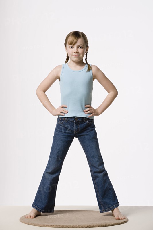 Portrait of girl (8-9) with hands on hips, studio shot. Photo: Rob Lewine