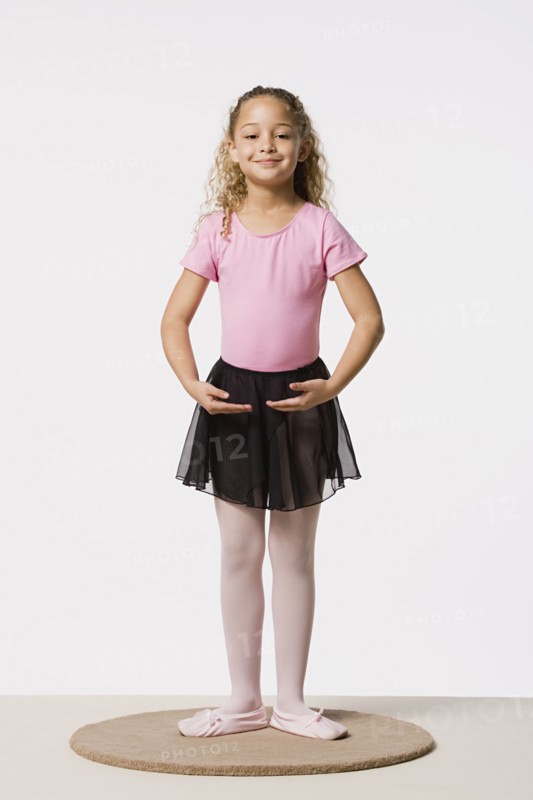 Studio portrait of smiling girl (8-9) in ballet costume. Photo : Rob Lewine