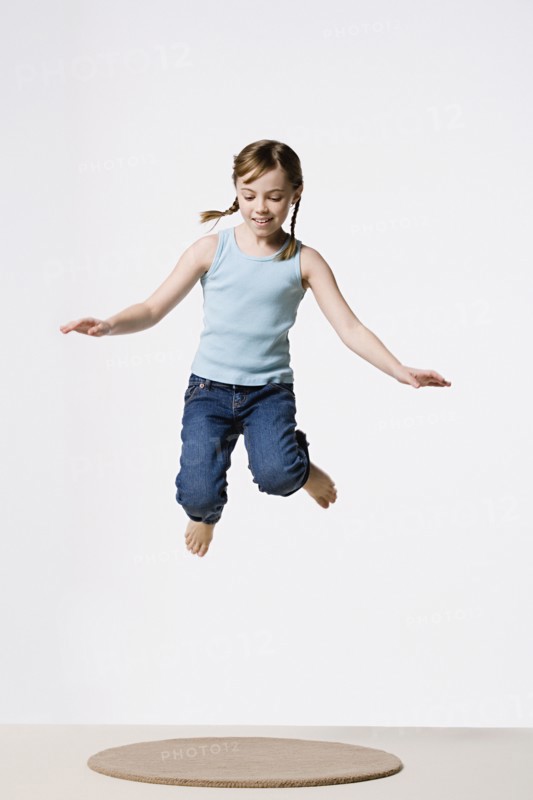 Studio portrait of girl (8-9) jumping. Photo: Rob Lewine
