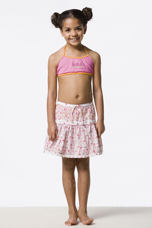 Studio portrait of smiling girl (8-9) with hair buns. Photo: Rob Lewine