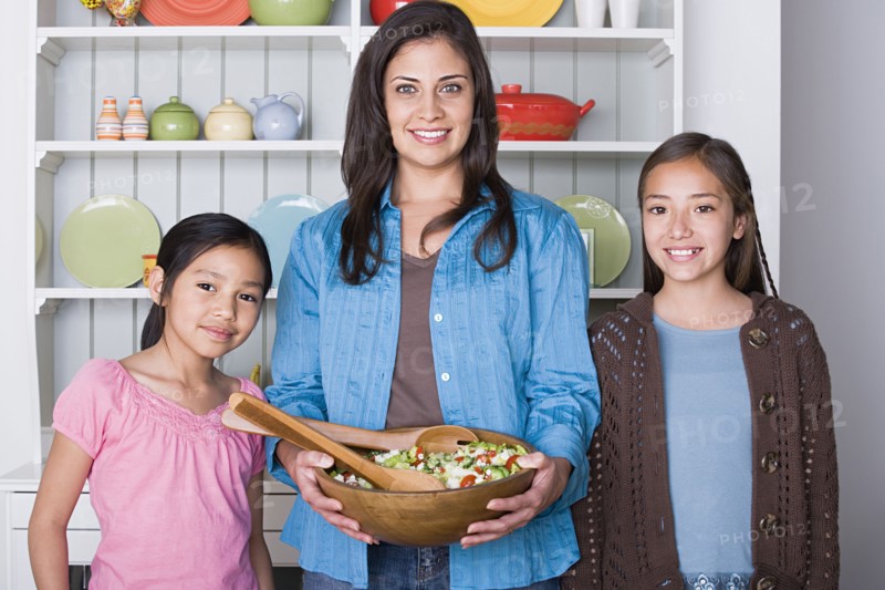 Portrait of mother with two daughters (8-9, 10-11) in kitchen. Photo: Rob Lewine