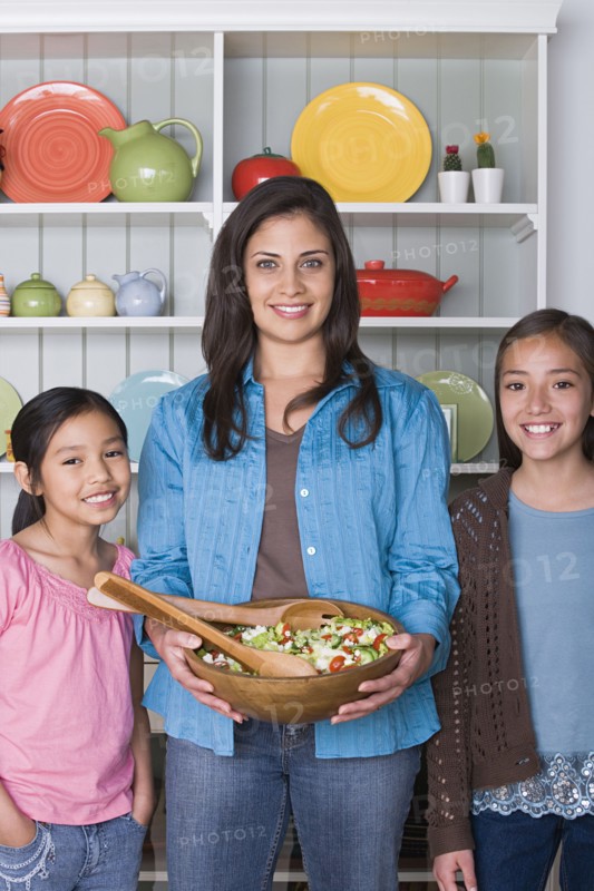 Portrait of mother with two daughters (8-9, 10-11) in kitchen. Photo : Rob Lewine