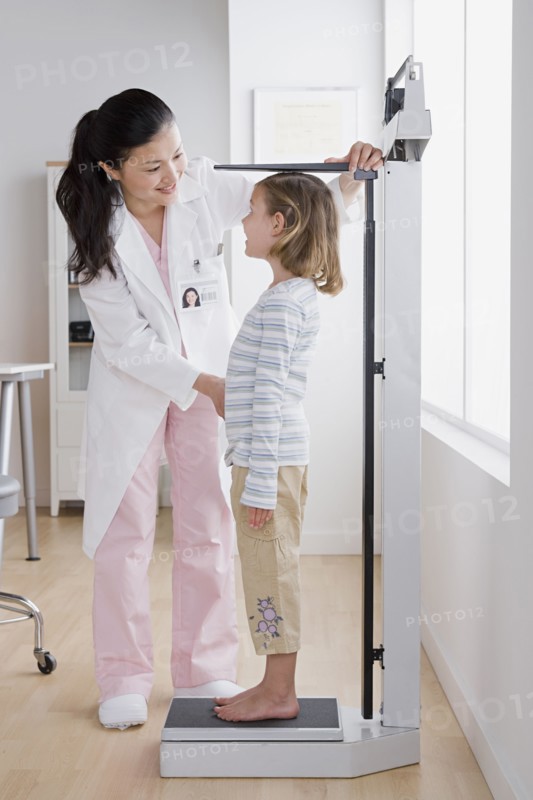 Female doctor measuring girl (4-5). Photo: Rob Lewine