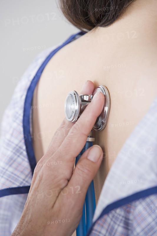 Close up of doctor's hand examining woman with stethoscope. Photo : Rob Lewine