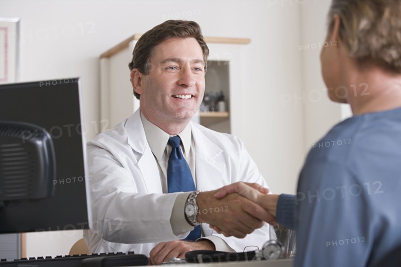 Male doctor shaking hand with patient. Photo : Rob Lewine