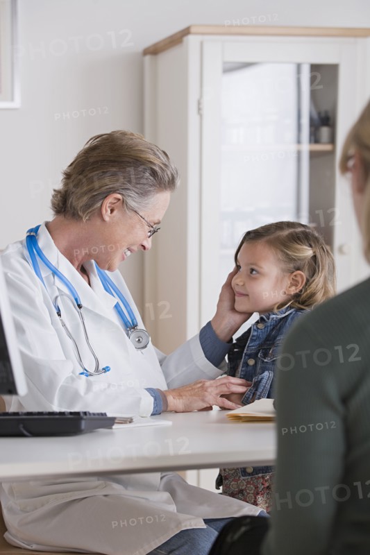 Female doctor stroking small girl (4-5). Photo: Rob Lewine