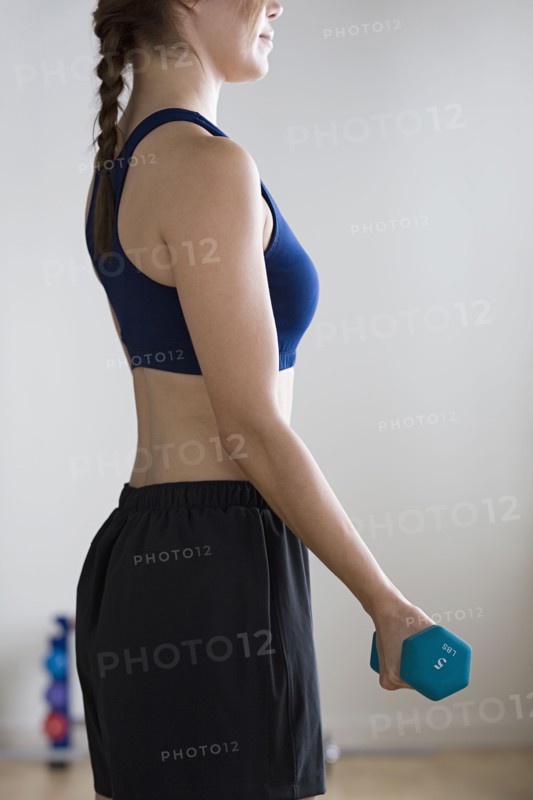 Woman lifting weights in gym. Photo : Rob Lewine