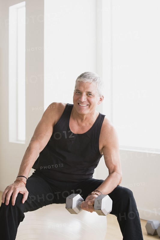Mature man an lifting weights in gym. Photo: Rob Lewine