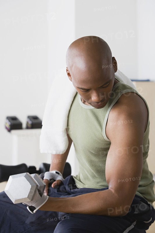 Young man lifting weights in gym. Photo : Rob Lewine