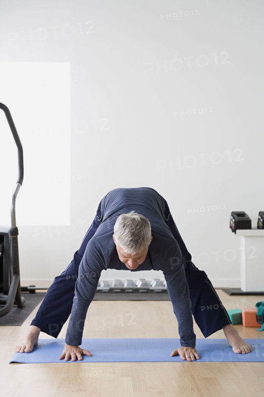 Man stretching in gym. Photo : Rob Lewine