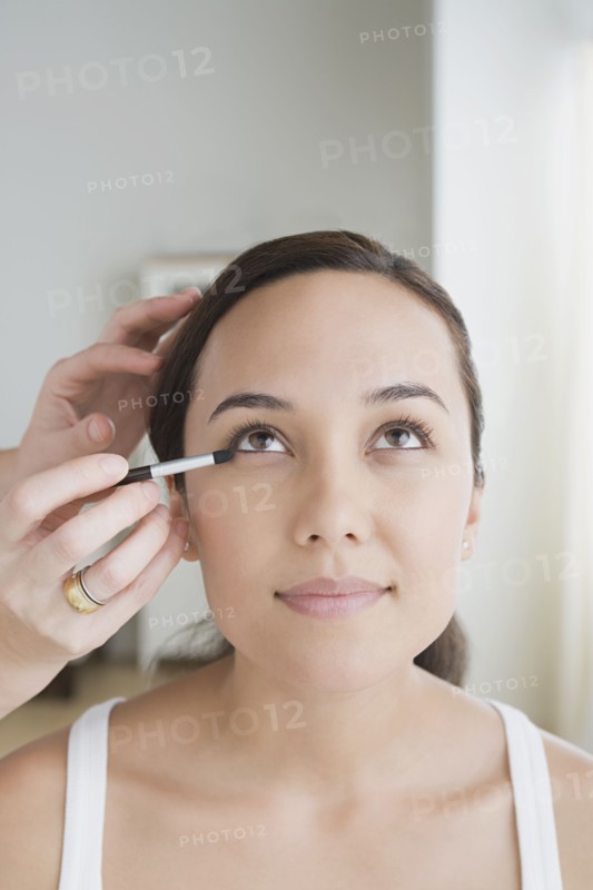 Woman having make-up applied. Photo : Rob Lewine