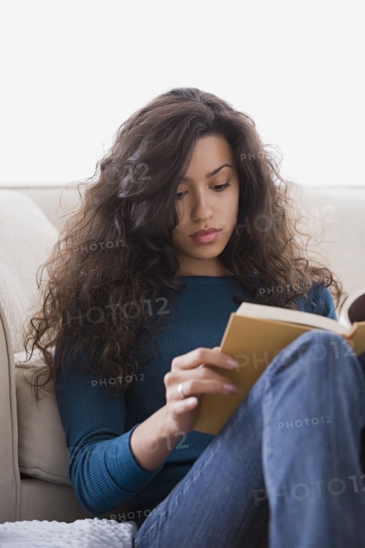 Woman reading book at home. Photo: Rob Lewine