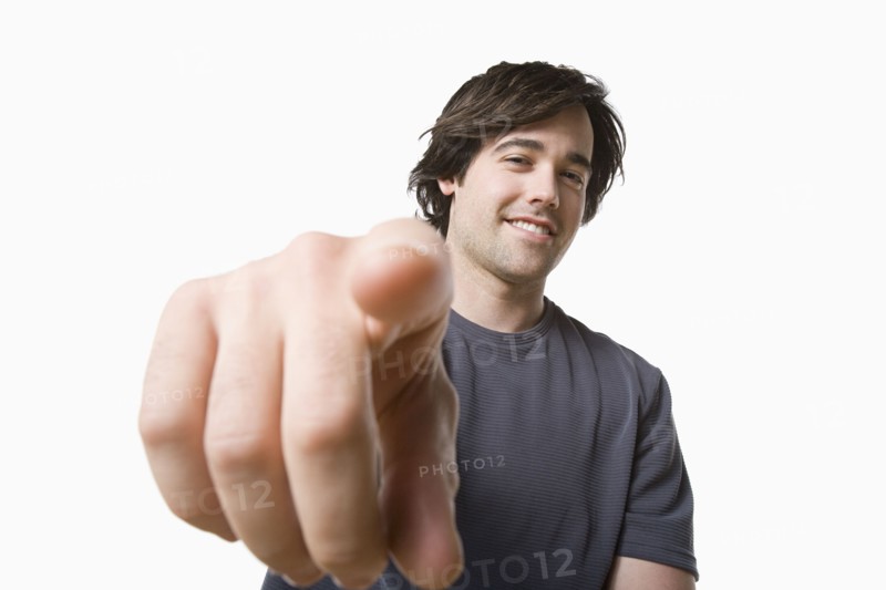 Studio portrait of young man pointing. Photo : Rob Lewine