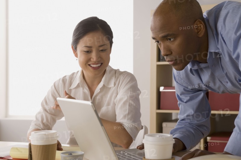 Two business people working in office. Photo : Rob Lewine
