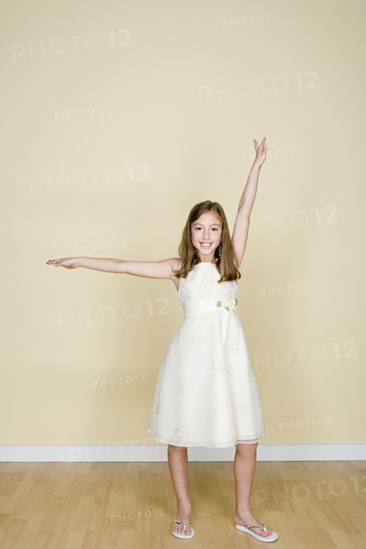 Portrait of happy girl (8-9) dressed in white. Photo: Rob Lewine