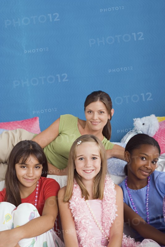 Portrait of woman and three girls (10-11) at slumber party. Photo: Rob Lewine