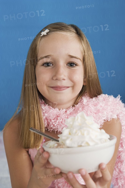 Portrait of girl (10-11) holding bowl with whipped cream. Photo: Rob Lewine