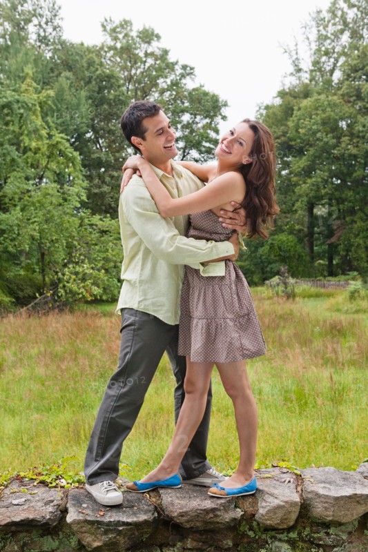 USA, New Jersey, Happy couple embracing on stone wall. Photo : Tetra Images