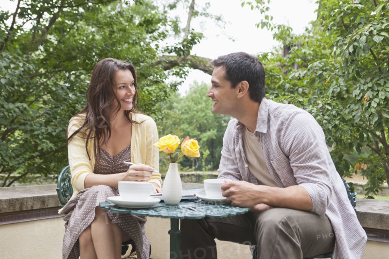 Happy couple sitting at table at outdoor cafe. Photo : Tetra Images