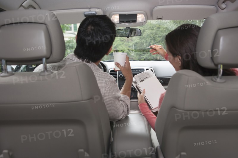 Rear view of couple in car. Photo: Tetra Images