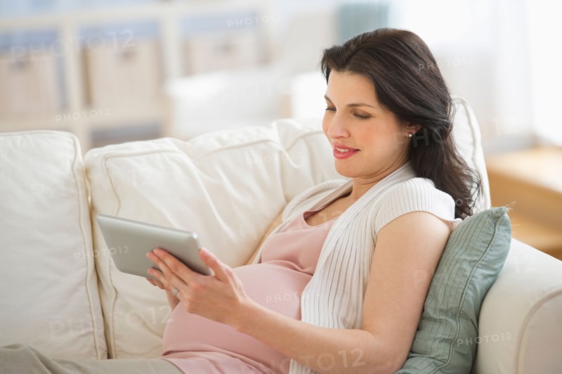Pregnant woman using tablet pc.