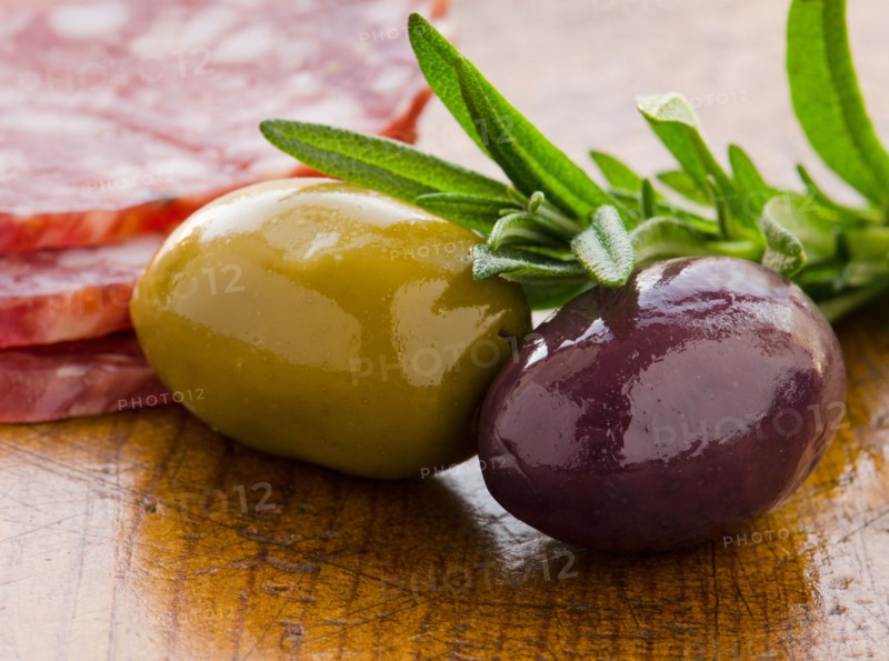 Close-up of green and black olives with rosemary, studio shot.