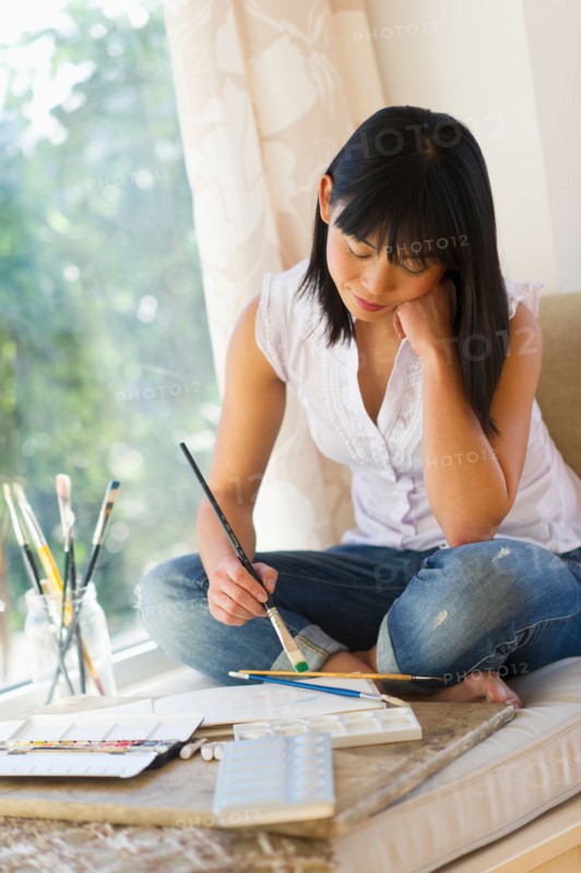 Mid adult woman painting at home.