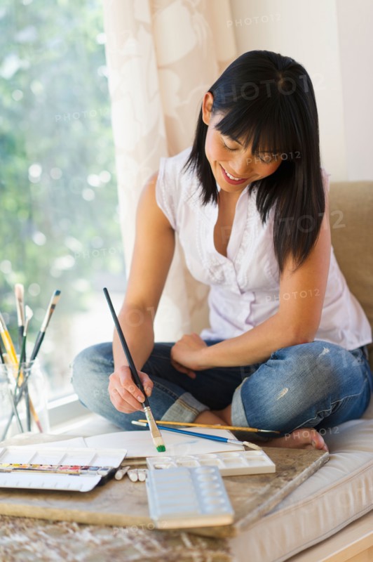 Mid adult woman painting at home.