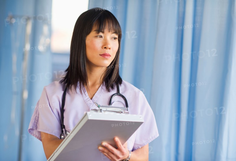 Doctor noting in medical chart of clipboard.