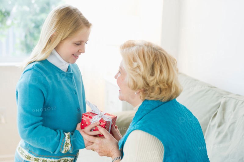 Granddaughter (8-9) receiving gift from grandmother.