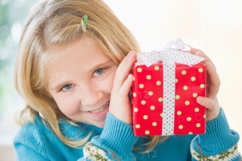 Portrait of smiling girl (8-9) holding gift.