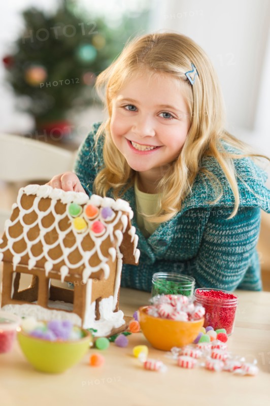 Girl (8--9) making gingerbread house.
