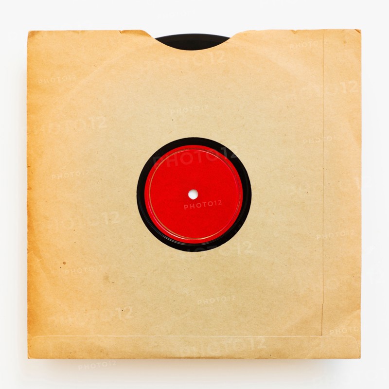Vinyl record in envelope on white background, studio shot.