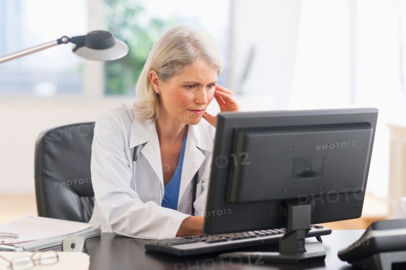 Senior female doctor working in her office.