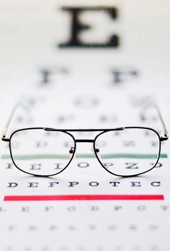 Close up of glasses on eye chart, studio shot.